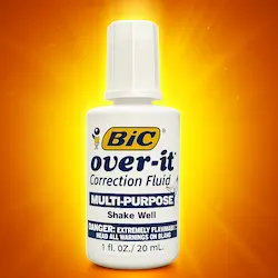 Frasco de líquido corrector blanco marca BIC Over-it sobre fondo naranja